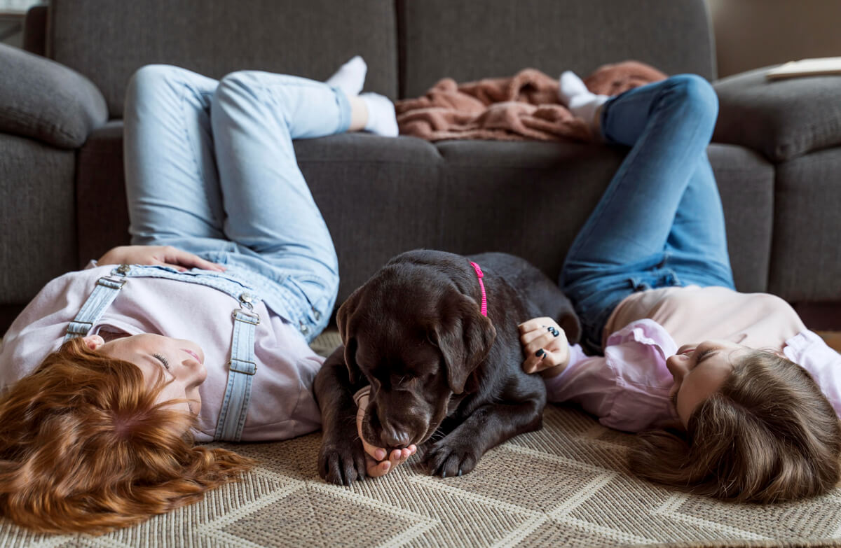 Women and dog laying on floor