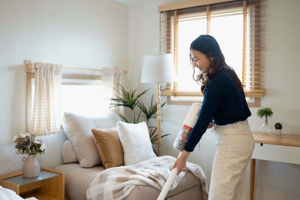 cheerful-young-woman-using-a-cordless-vacuuming-fl-2025-04-27-10-52-24-utc