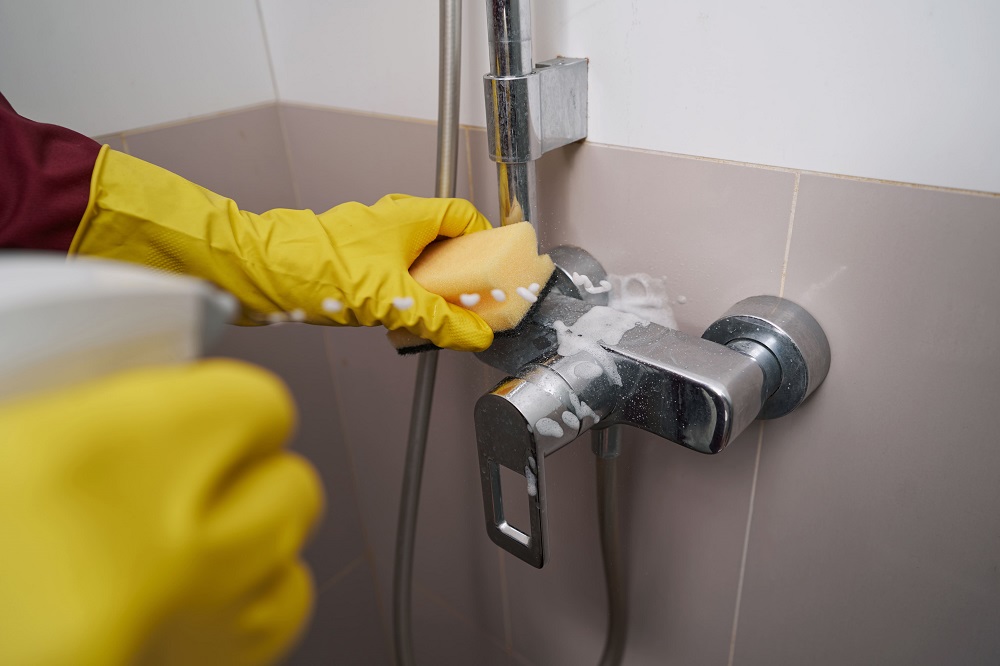 cleaner-in-rubber-gloves-washing-bathroom-tap-with-2025-03-05-13-39-48-utc